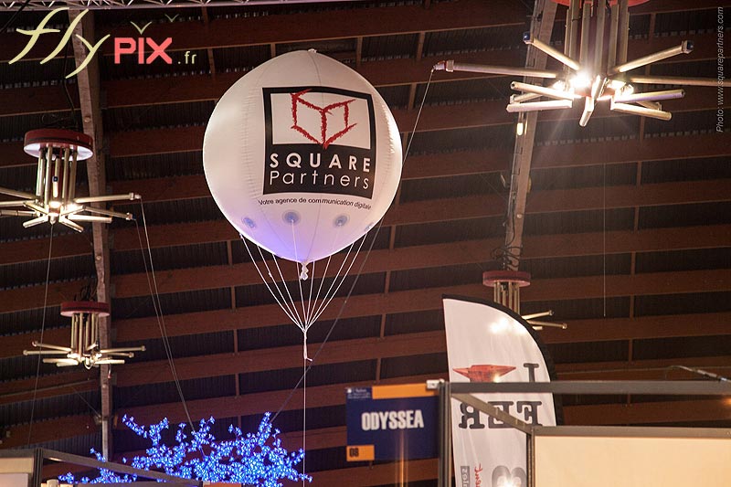 Ballon publicitaire sphérique gonflé à l'hélium pour square partners dans un salon d'exposition pour l'animation d'un stand.