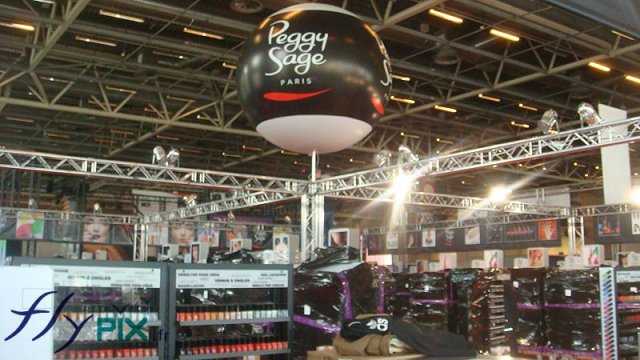 Ballon PVC sur mât télescopique en aluminium posé pendant un stand lors d'un salon professionnel.