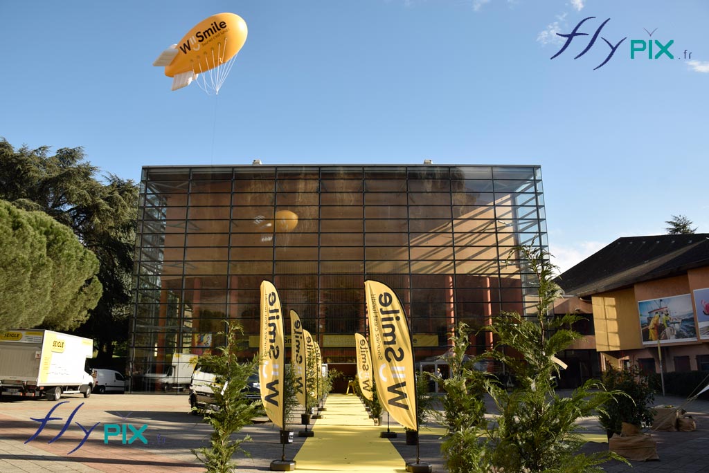 Ballon dirigeable publicitaire personnalisé, zeppelin pour We Smile + 10 oriflammes grandes tailles