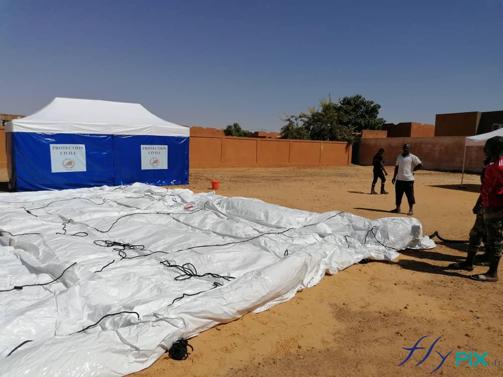 Une tente gonflable médicale de premiers secours, en cours de test de gonflage par les officiers et les militaires de la Protection Civile du Niger, en Afrique.