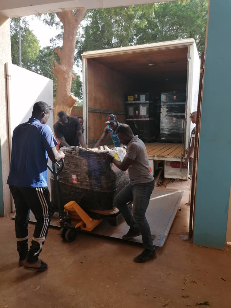 Un groupe de technicien est entrain de livrer des tentes PMA, ici au déchargement du camion.