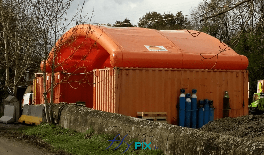 Préau gonflable en PVC, une structure gonflable air captif, fixé entre 2 containers maritimes.