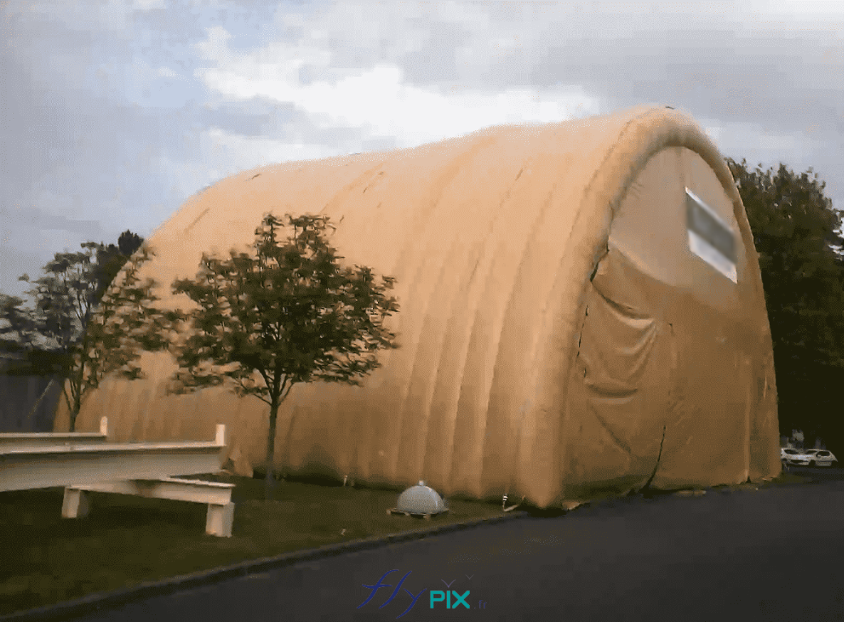 NEXTER : une vue générale d'un grand hangar gonflable militaire, en 2 modules, en forme de tunnel, entièrement en enveloppe PVC double peau capitonnée. Cet abri gonflable militaire peut être déployé très rapidement dans n'importe quel endroit, en cas de conflits militaires. Il peut accueillir des officiers, des soldats, des militaires, des parachutistes ou des techniciens.