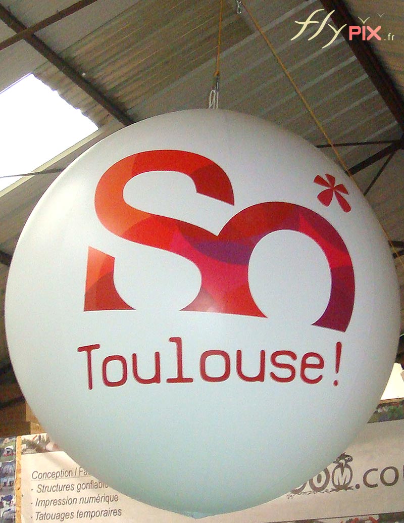 Ballon publicitaire de forme sphérique avec marquage en impression numérique couleur sur fond blanc, enveloppe PVC 0,18 mm.