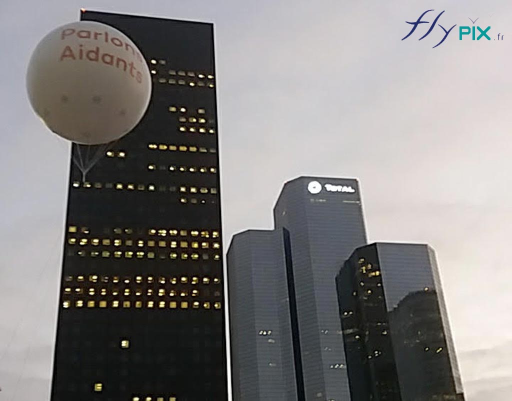 Un ballon publicitaire gonflé avec du gaz hélium, en enveloppe PVC 0.18 mm, survole La Défense à Paris.
