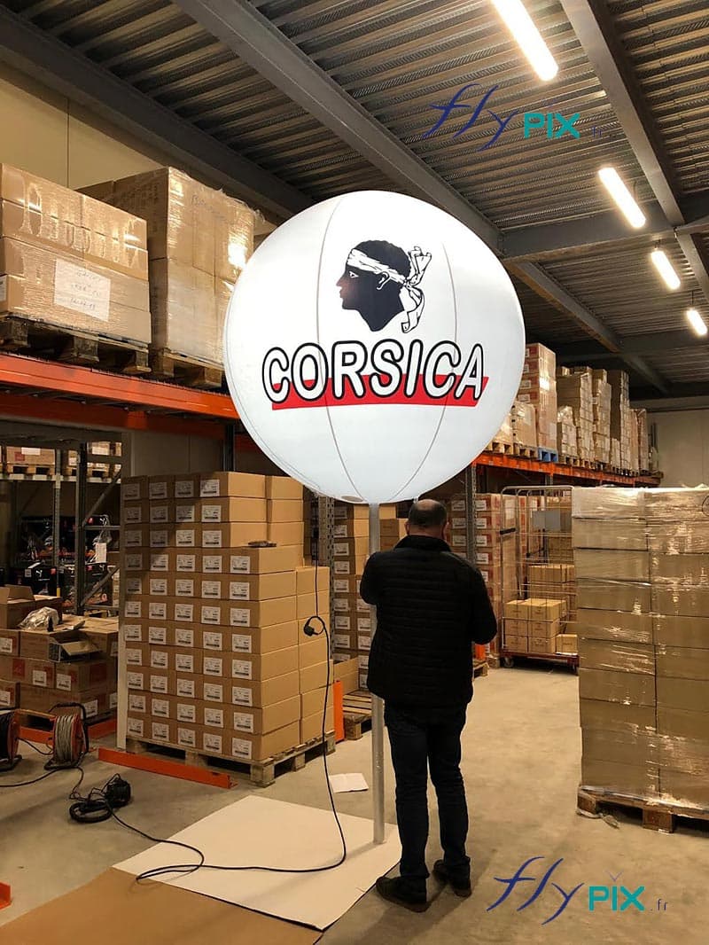 Un technicien est entrain de tester et de monter le ballon sur mat imprimé CORSICA