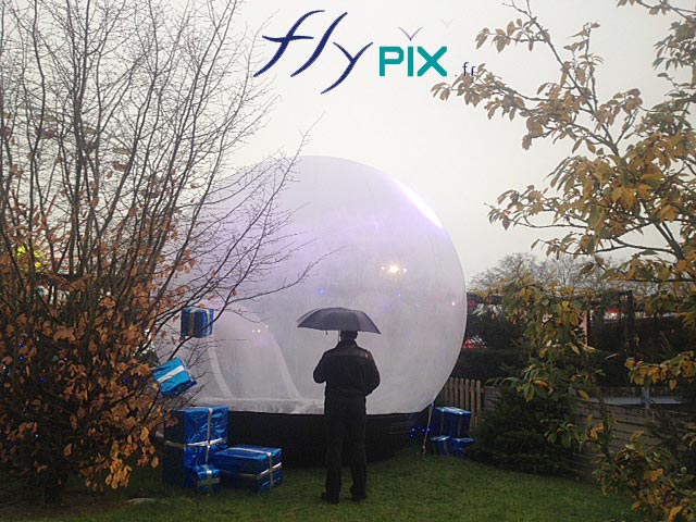 Ballon boule Noël avec enveloppe PVC transparente pendant une animation hivernale en extérieur.