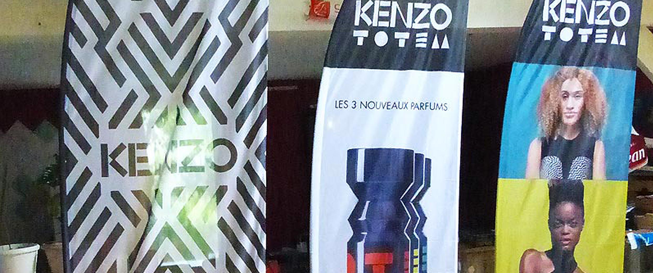Voici des oriflammes avec marquages personnalisés réalisés pour la promotion de la marque Kenzo, dans le cadre d'une journée portes ouvertes dans un centre commercial, pour une boutique de parfums et de produits cosmétiques.